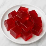 Bariatric gelatin recipe in four 60 ml silicone cups, fresh mint garnish, white marble counter 6 g protein per serving