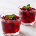 Chilled berry juice gelatin dessert recipe card with mint garnish