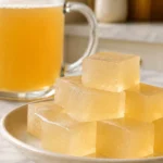 Daily horse gelatin dosage for men shown with a measured tablespoon of unflavored gelatin powder beside a small glass of warm water