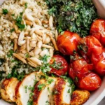 low salt chicken quinoa bowl served with kale tomatoes and almonds in a white bowl