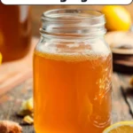 Three bottles of homemade kombucha in different flavors including ginger lemon, berry burst, and tropical twist lined up on a kitchen counter